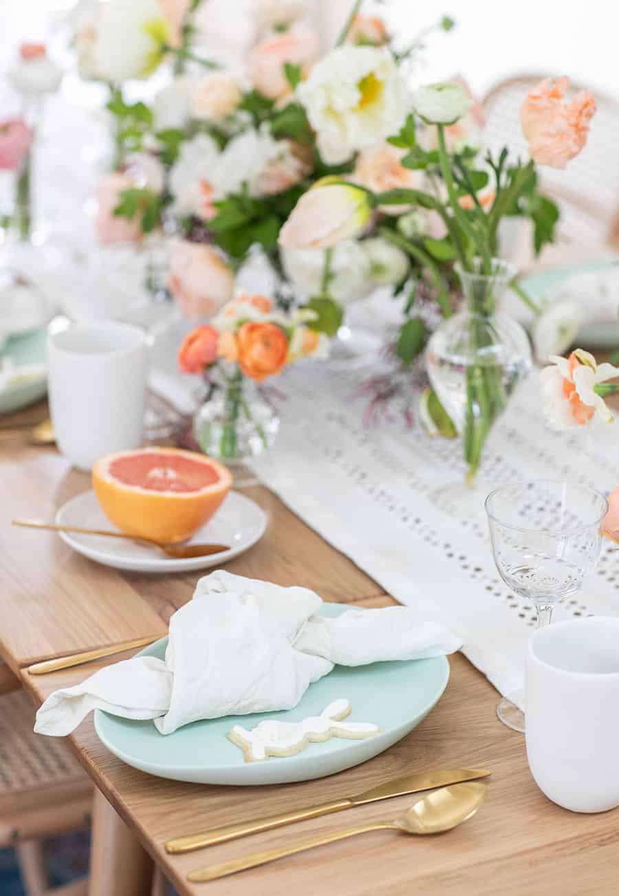 Easter brunch table setting with napkin and gold silverware. 