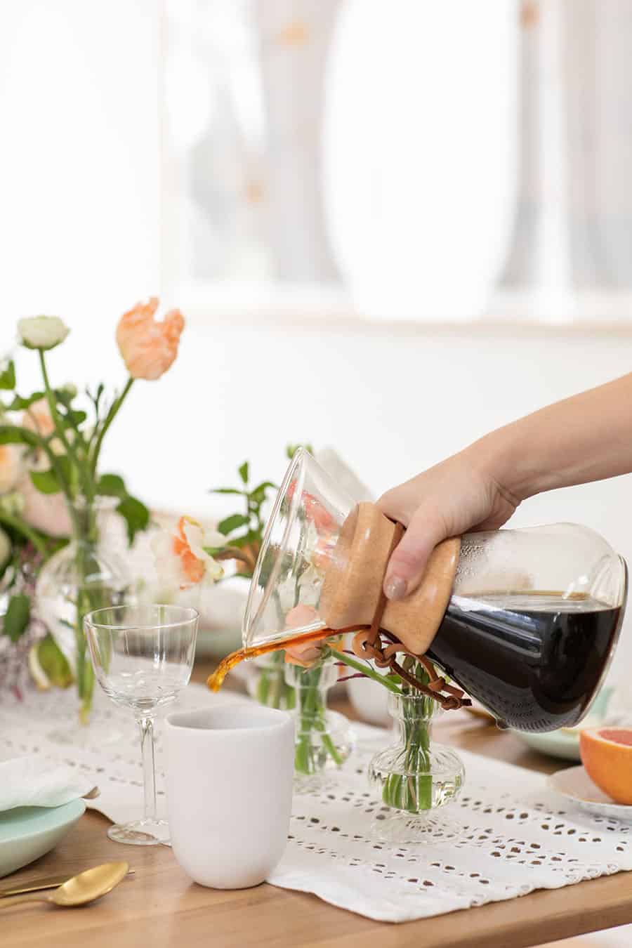 Eden Passante pouring coffee into a coffee mug.