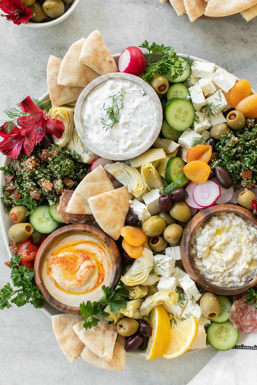 Fácil plato de Mezze griego con yogur y bonitos aderezos como aceitunas, rábano, pan.