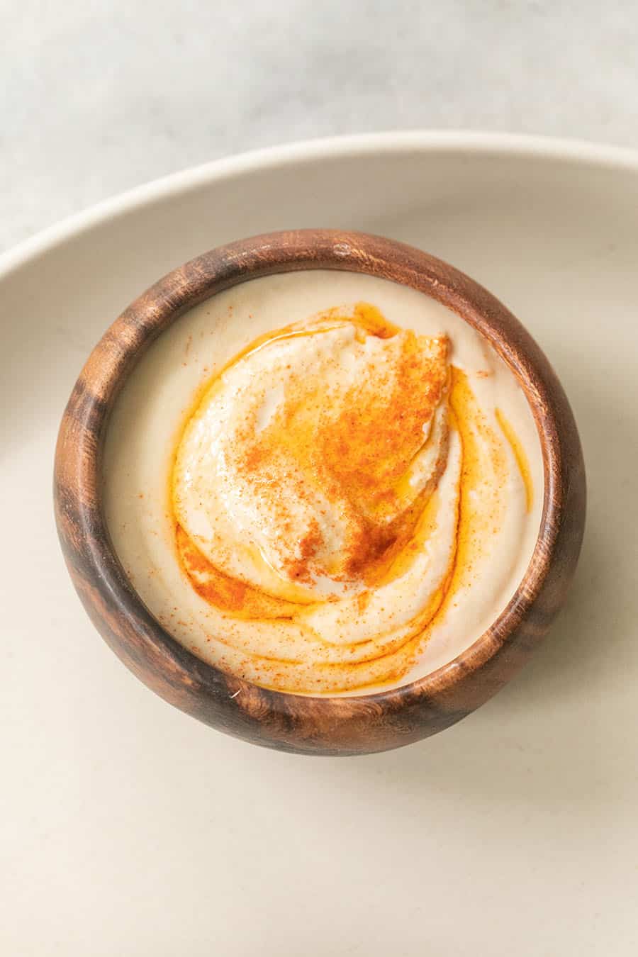 Hummus en un bol marrón sobre una bandeja