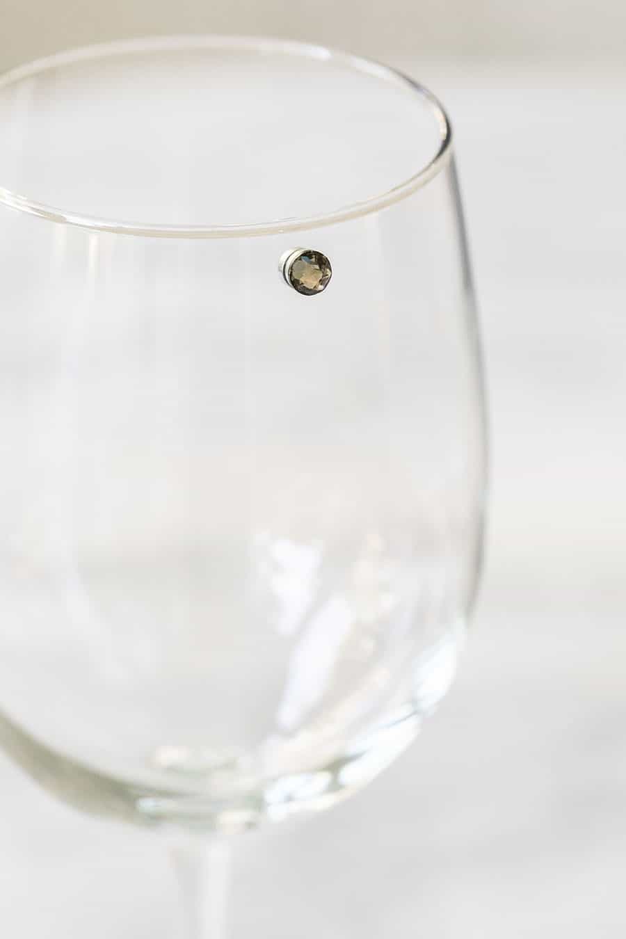 Wine charm on a glass to mark different glasses. 