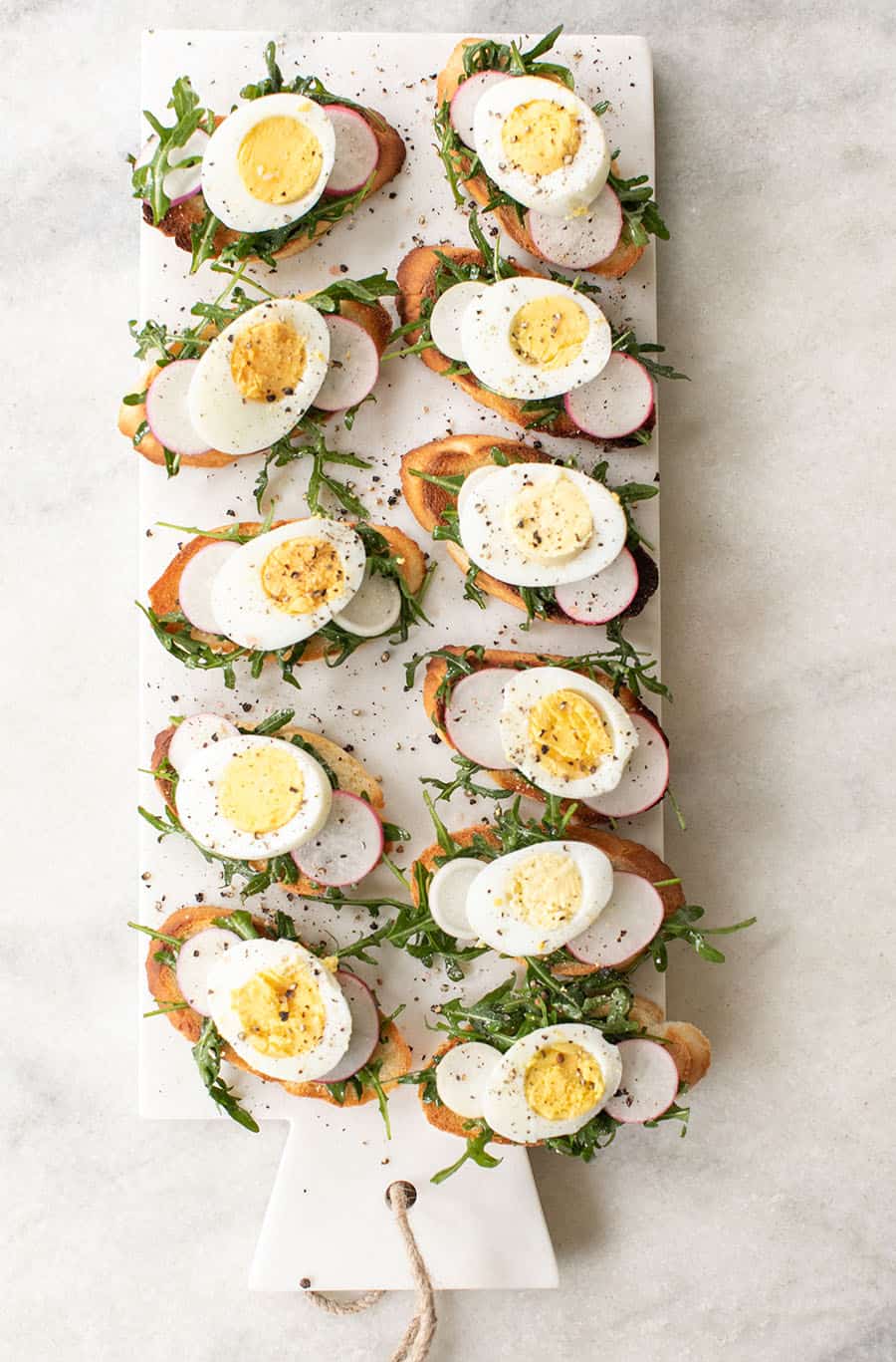 Crostini recipe with hard boiled eggs, arugula, salt and pepper.