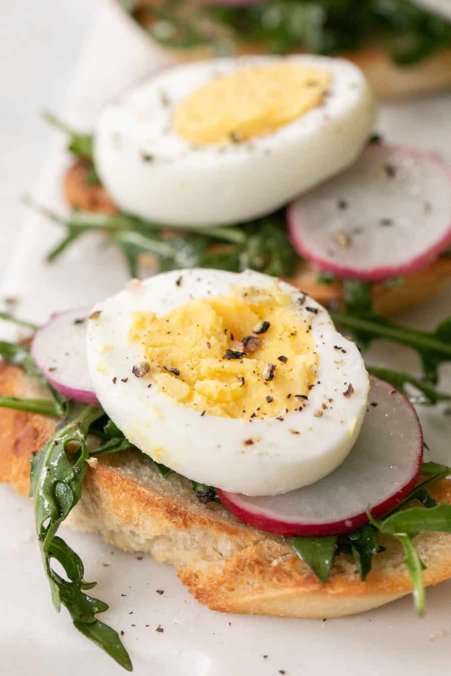 Hard boiled egg crostini with salt and pepper.