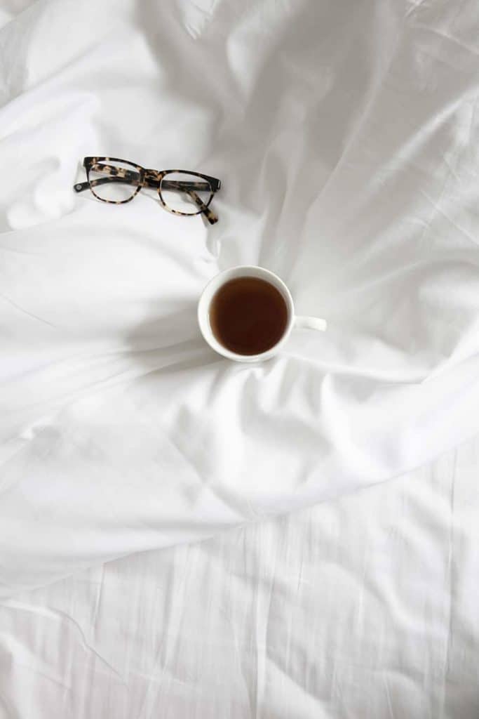 Photo of coffee on bed sheets.