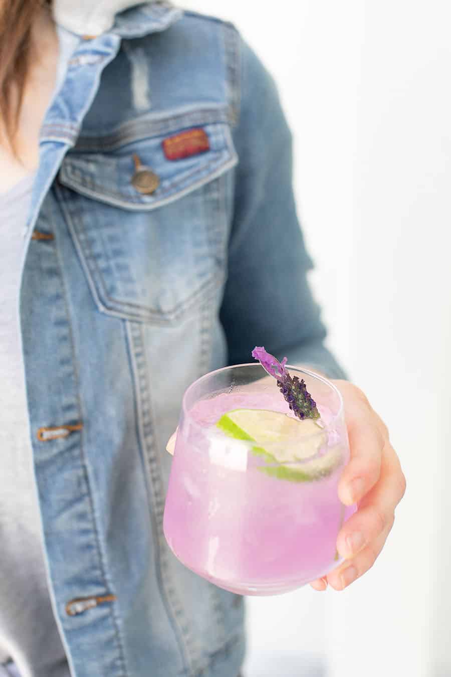  dívka drží fialový gin a tonikum punč 