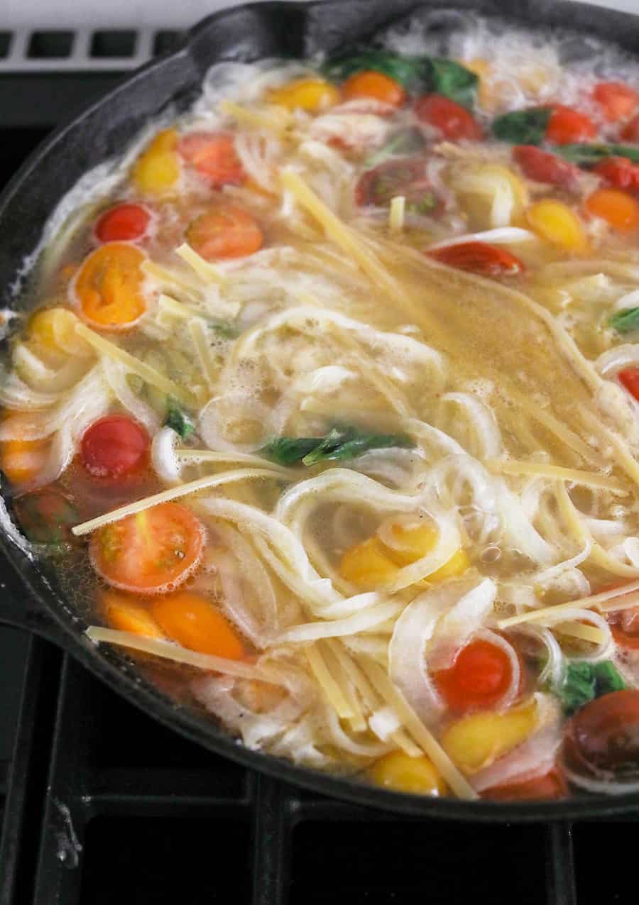 One Pan Basil and Tomato Pasta cooking in a cast iron pan. - tomato basil pasta