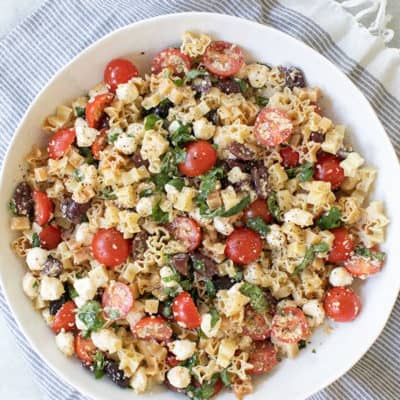 The best pasta salad recipe with cherry tomatoes, olive oil, cheese, olives, garlic and basil.