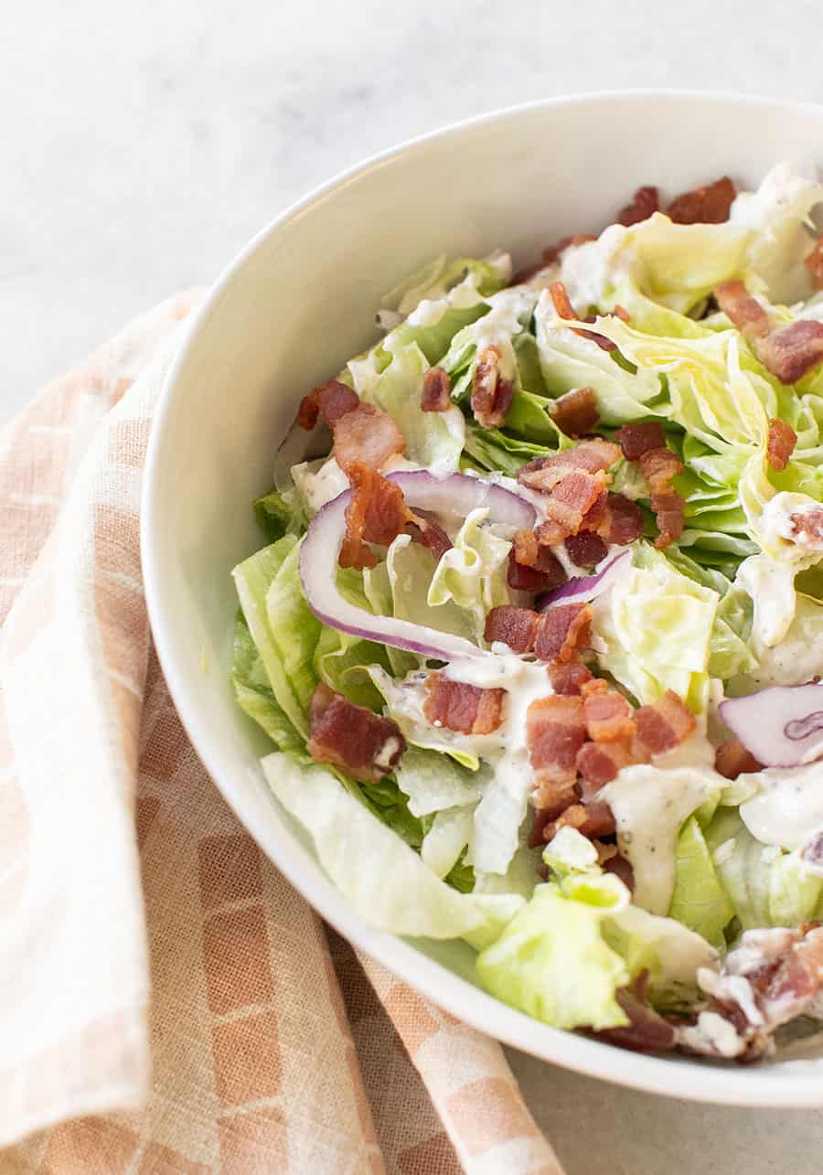 Chopped wedge salad with bacon, onions and dressing.