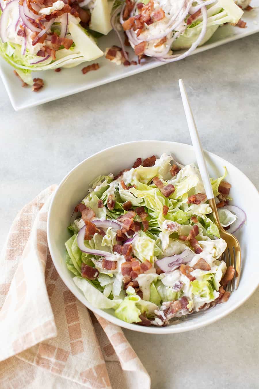 Wedge salad in a white bowl chopped.