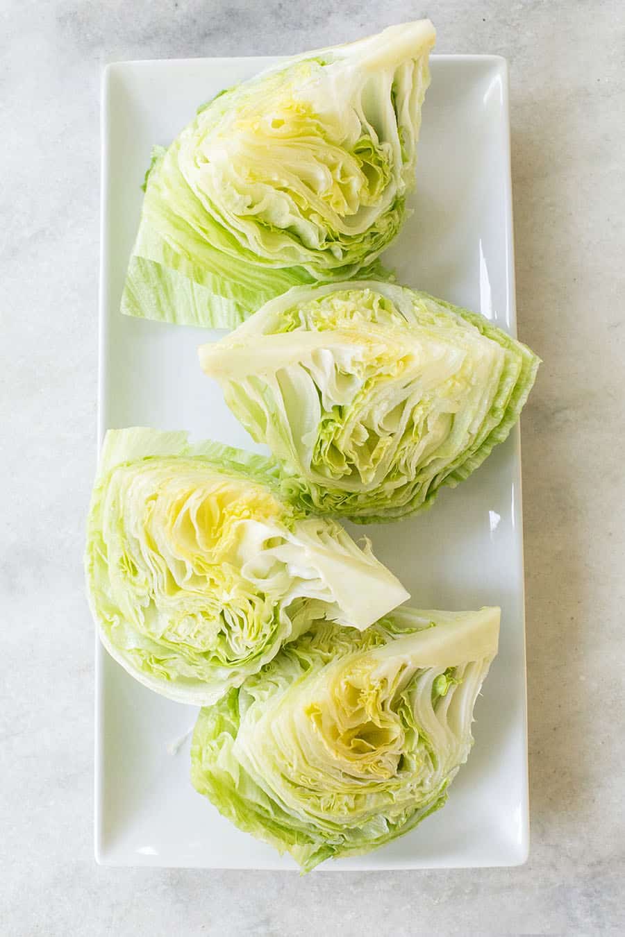 Salad cut into wedges on a white platter