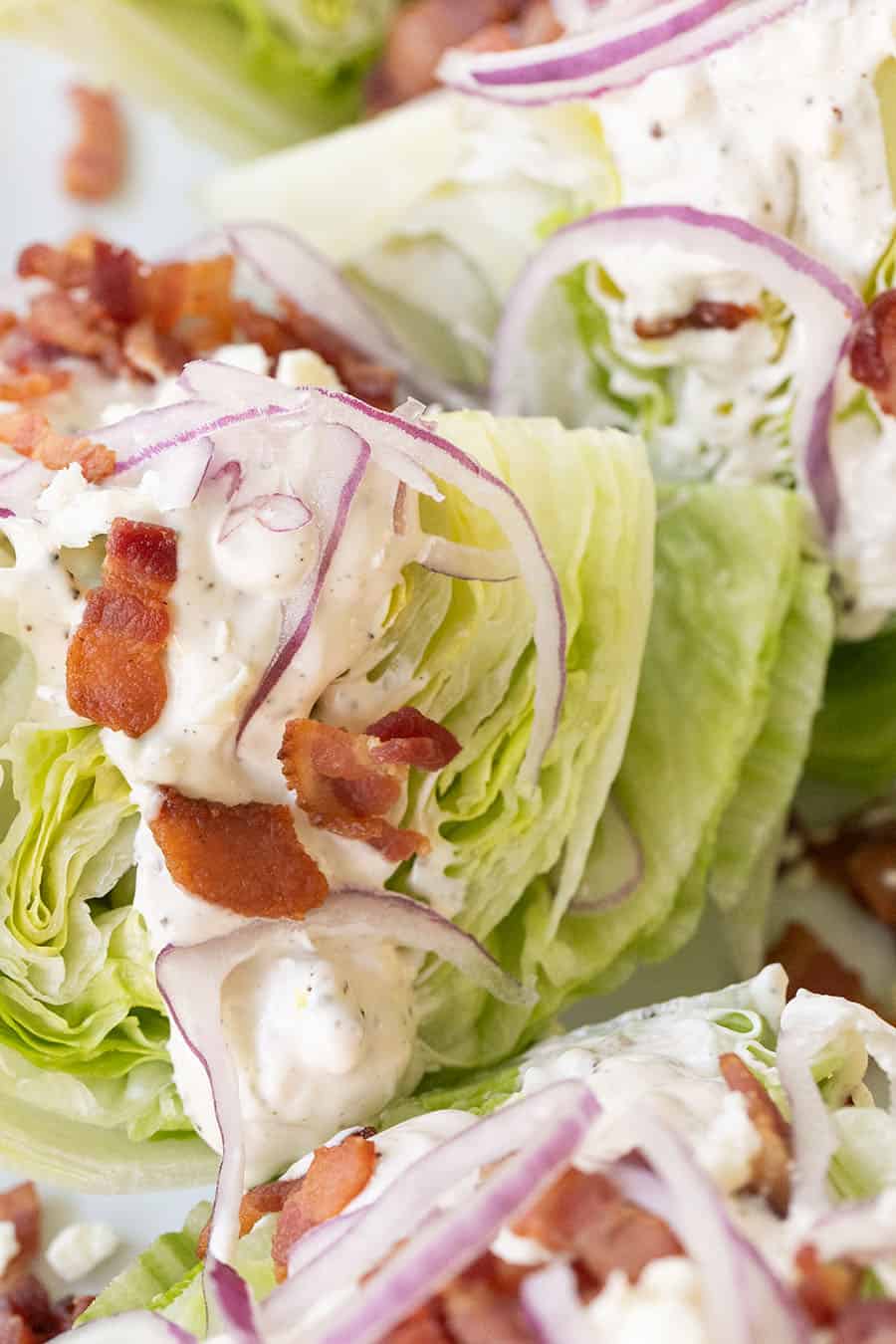 Wedge salad recipe with dressing, bacon and onions.