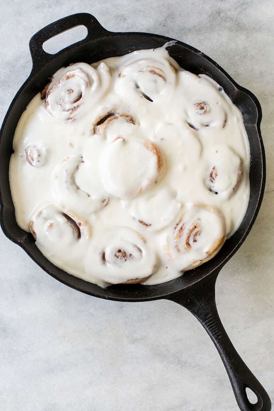 Easy Semi-Homemade Cinnamon Rolls with Cream Cheese Glaze in a cast iron skillet.