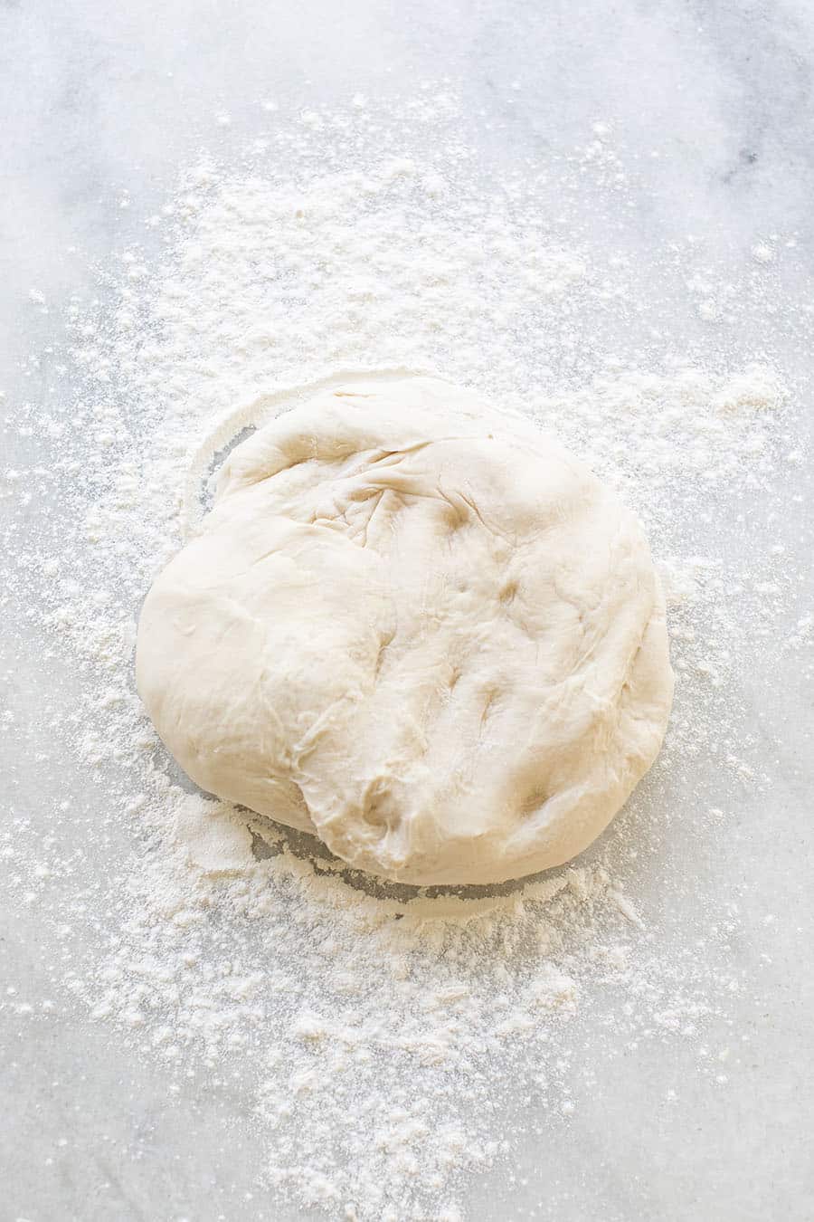 Bread dough on a table with flour.