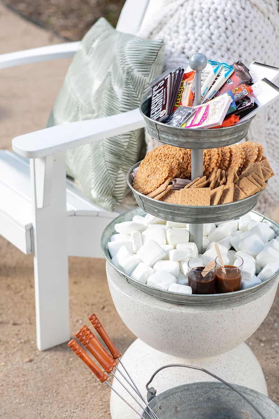 Tiered Galvanized Tray with chocolate candy bars on the top, graham crackers in the middle and marshmallows at the bottom. 