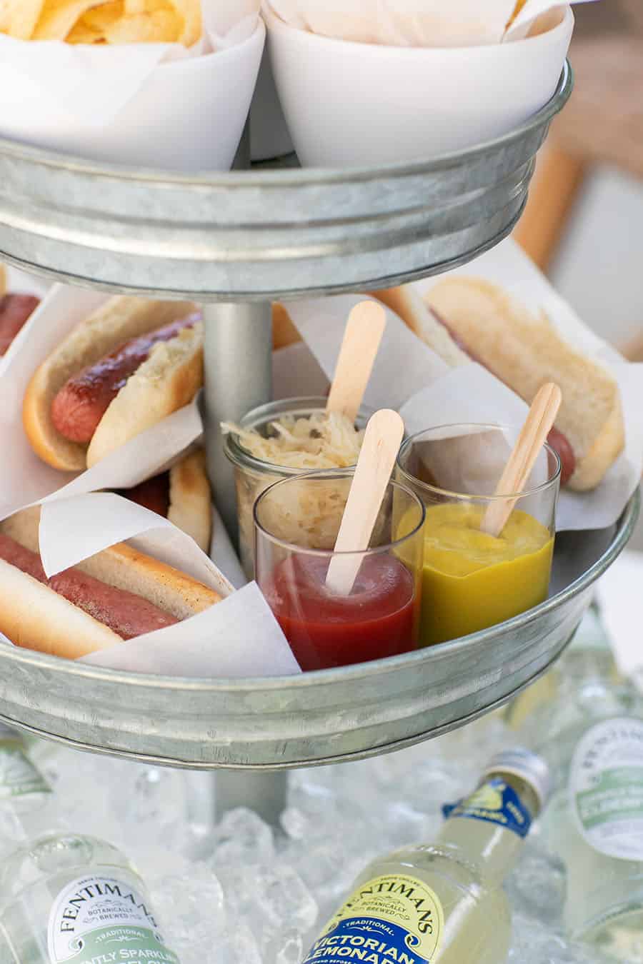 Tiered Galvanized Tray with hot dogs and mustard and ketchup.