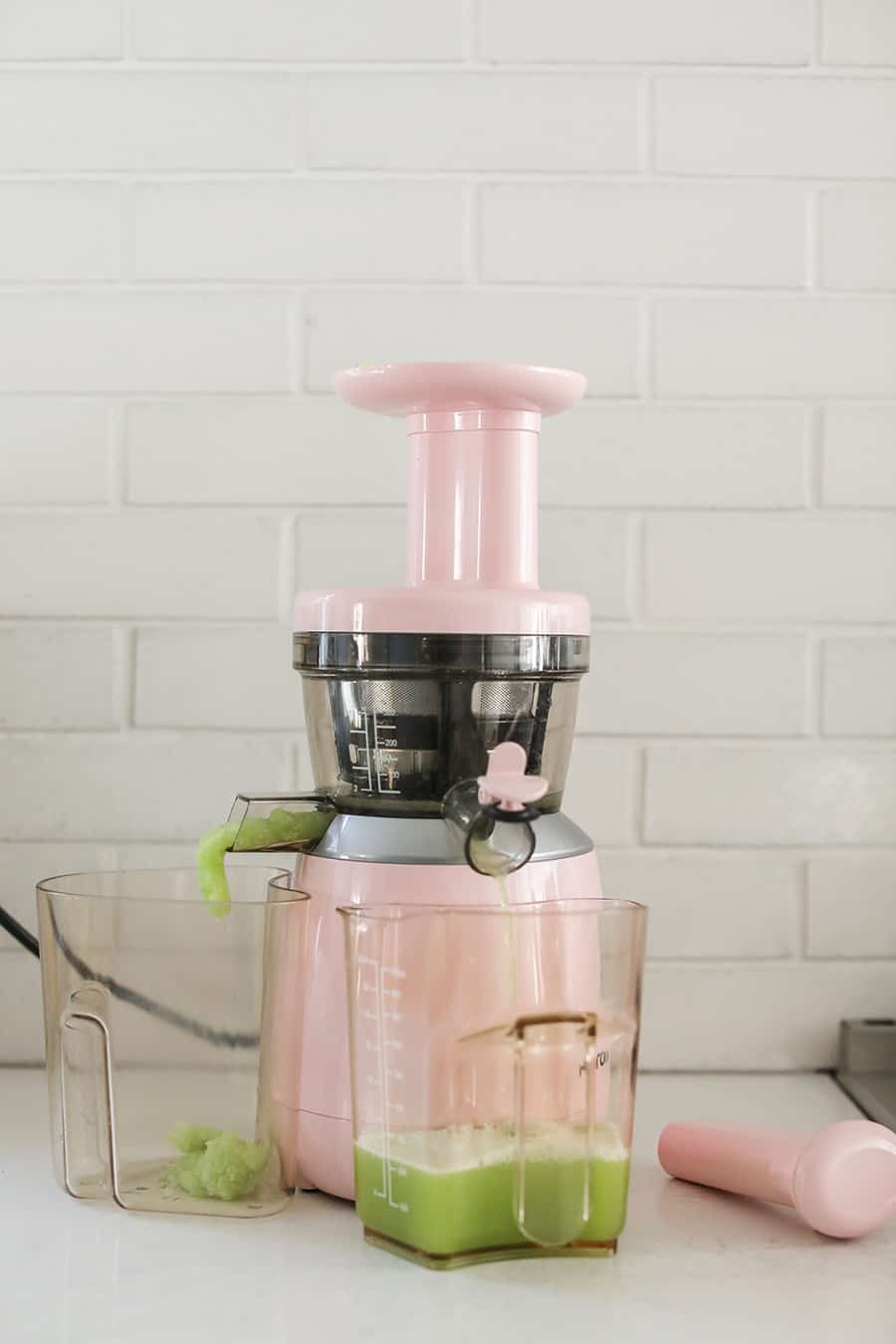 Making juice in a pink juicer.