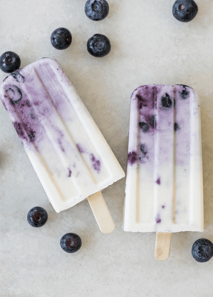 Blueberry cream pops on marble table with blueberries - popsicle sticks