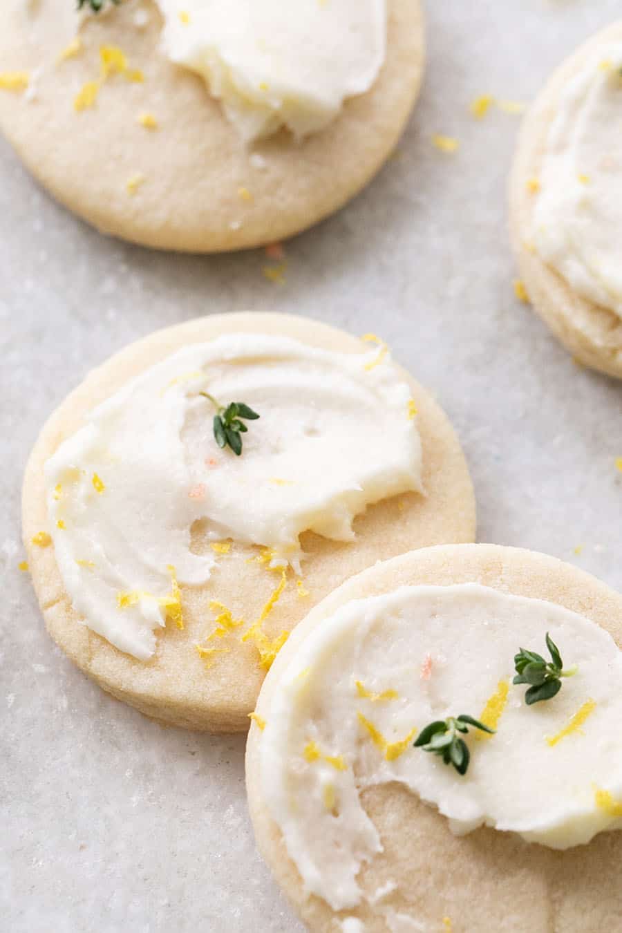 Lemon shortbread cookies with lemon frosting and a sprig of thyme.