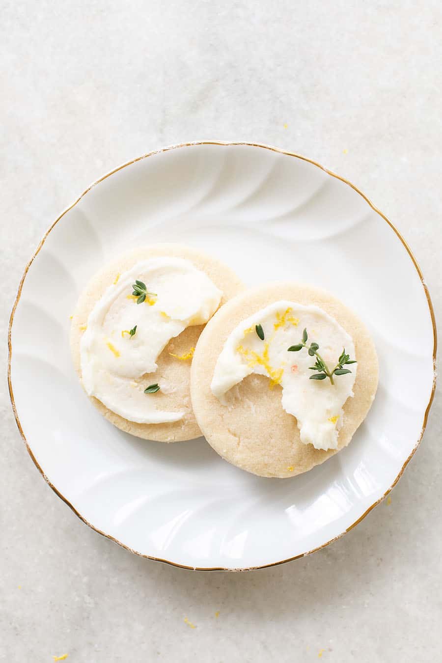 two Shortbread Cookies on a white plate with frosting 