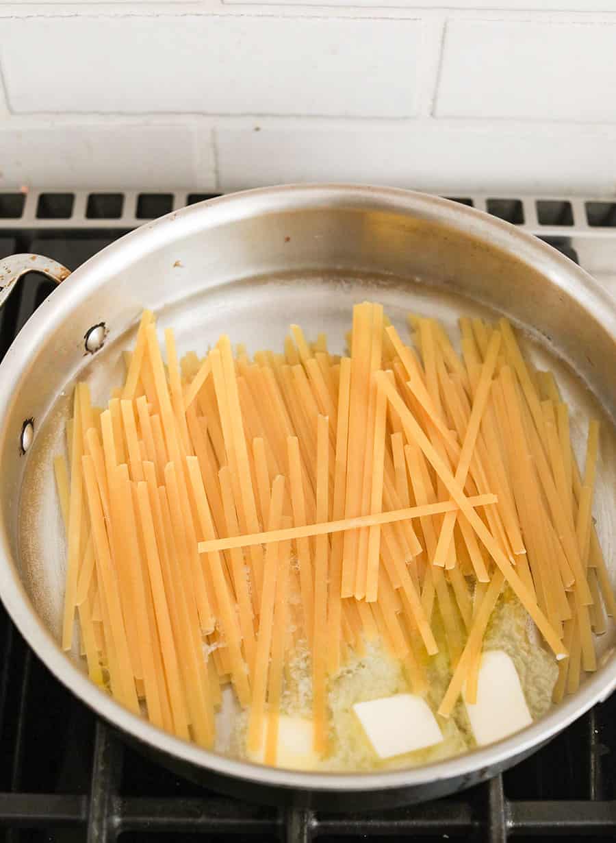 Fettuccine noodles in pan with butter.