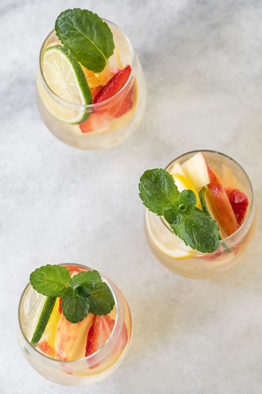 Three glasses of white wine sangria with fresh mint. 