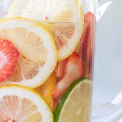 Easy white wine sangria recipe with lemon and lime slices and strawberries, and apple vodka.