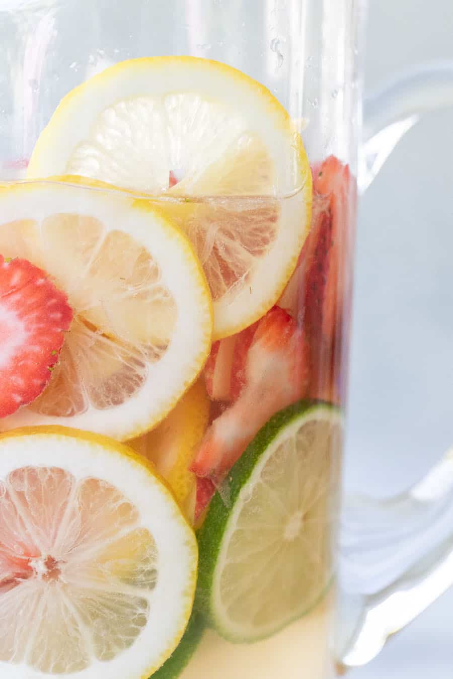 Easy white wine sangria recipe with lemon and lime slices and strawberries, and apple vodka. 