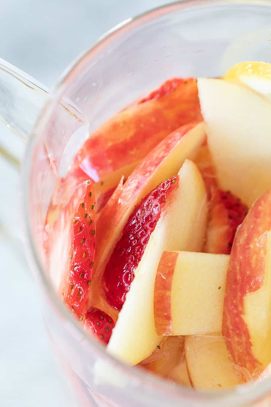 Apple slices in a glass pitcher. 