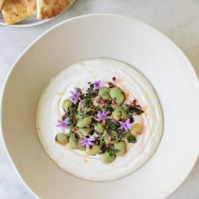 Recipe for yogurt tahini dip topped with lima beans, lemon, olive oil and green onions.