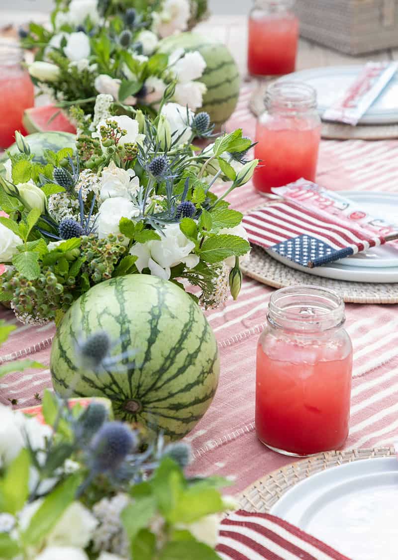 Watermelon, flower arrangements and a jar full of watermelon juice