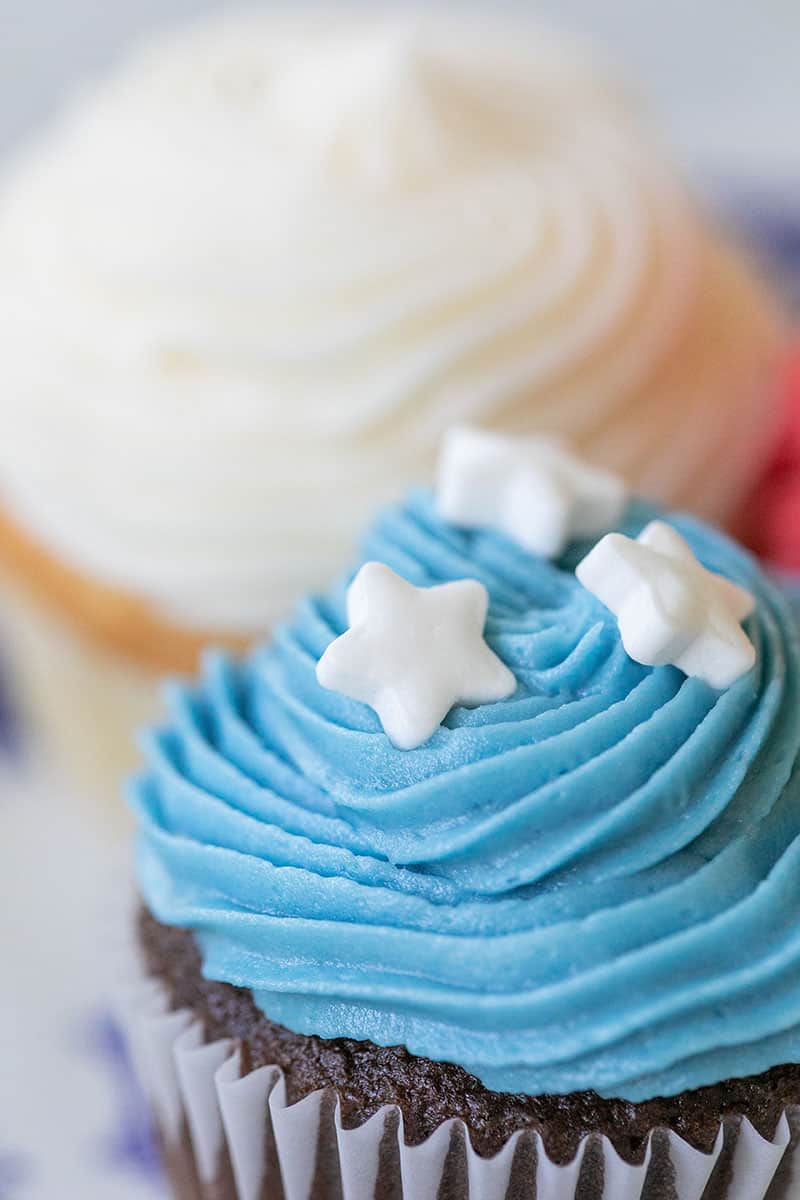 Mini cupcake with blue frosting and white sprinkle stars/