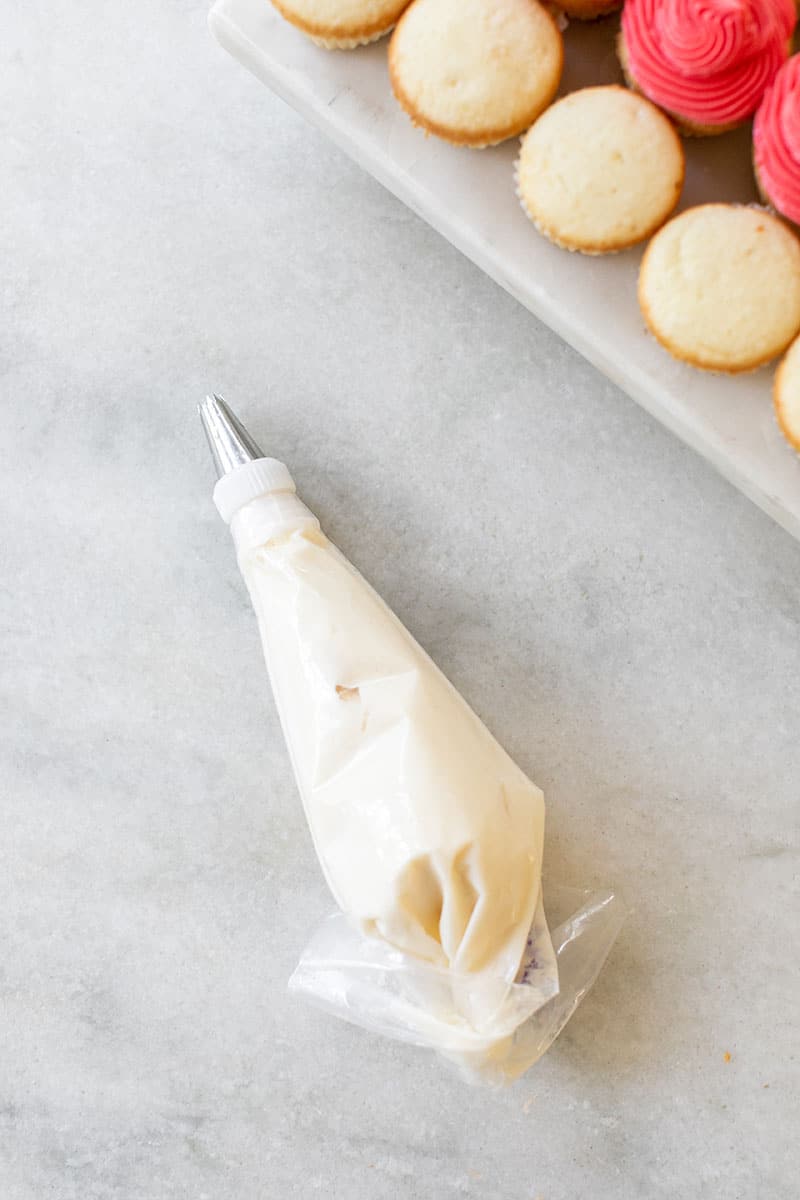 Frosting in a piping bag on a marble table. 