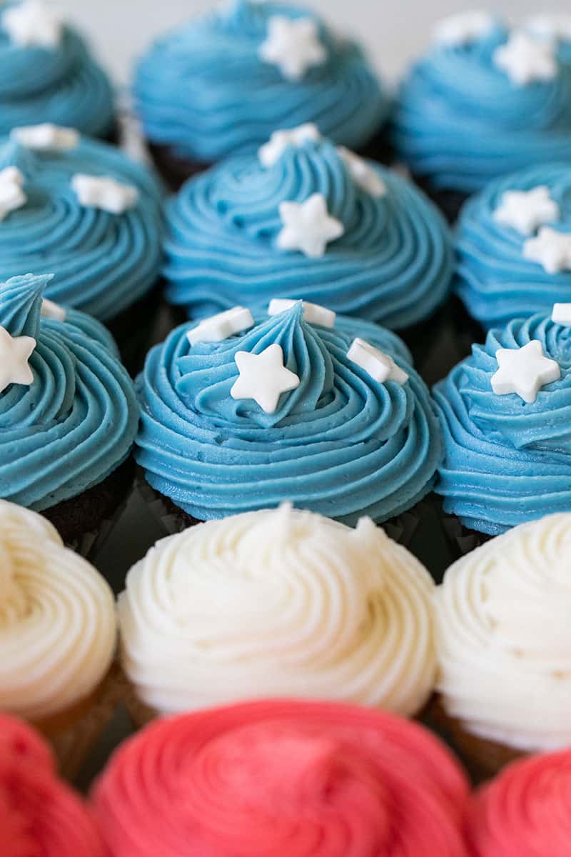 Mini cupcakes with blue and white and red frosting. 