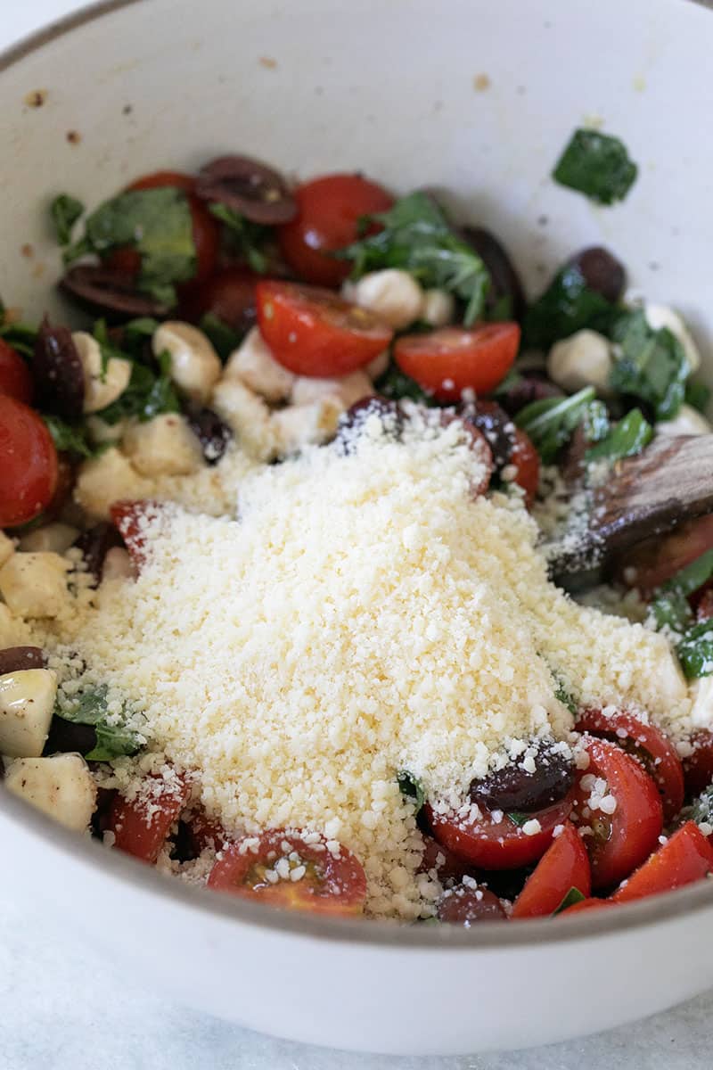 Parmesan cheese in a bowl of summer pasta salad. 