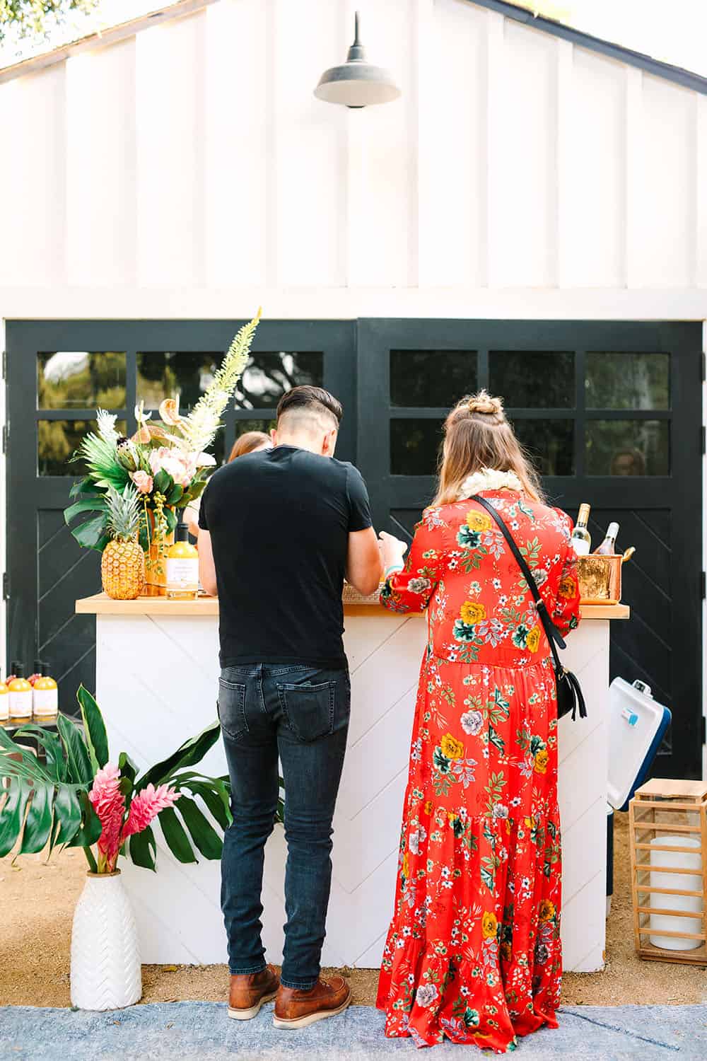 Backyard summer tropical party with guests at a bar.