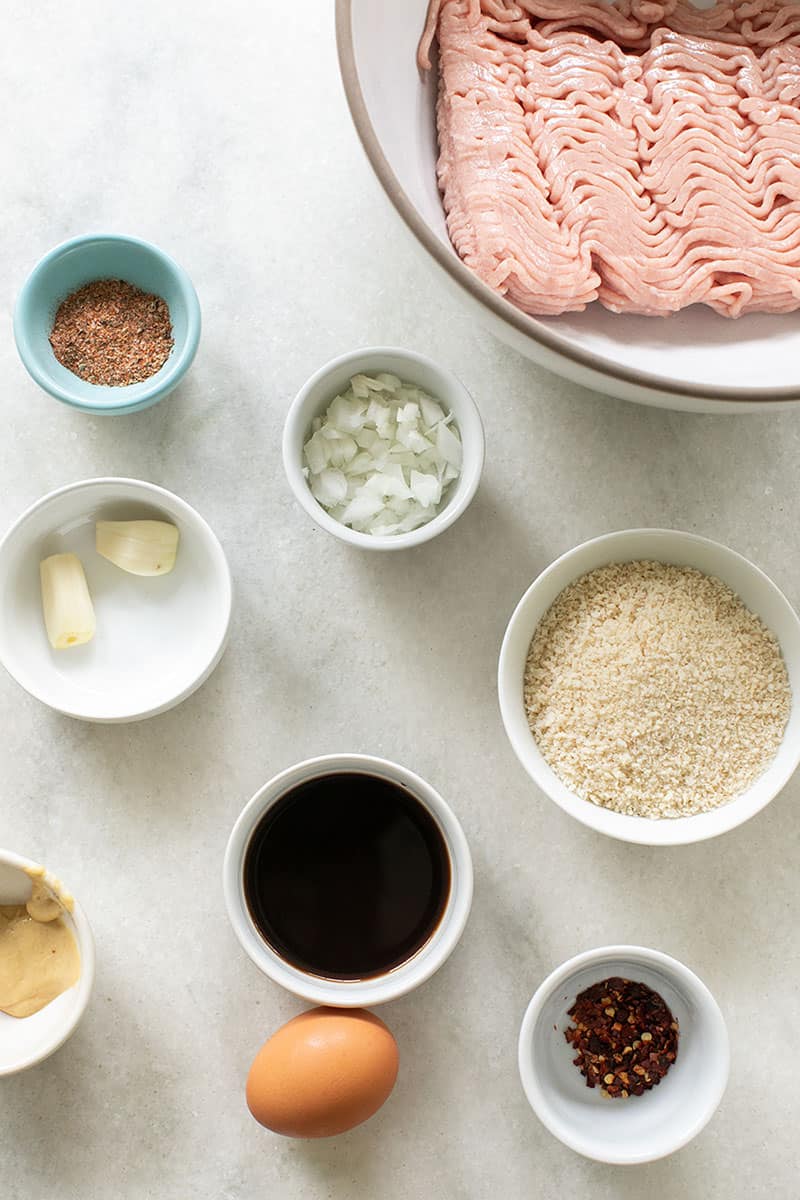 Ingredients for homemade turkey meatballs on a marble table. 