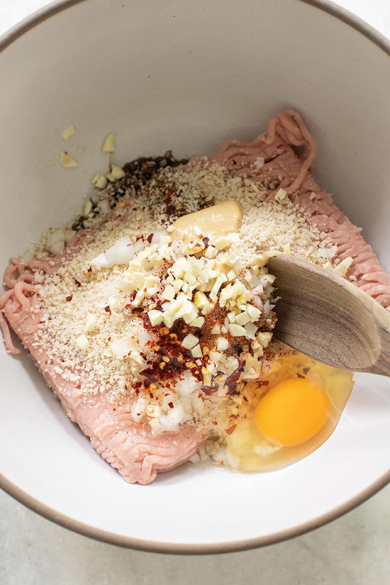 Stirring ingredients to make turkey meatballs.