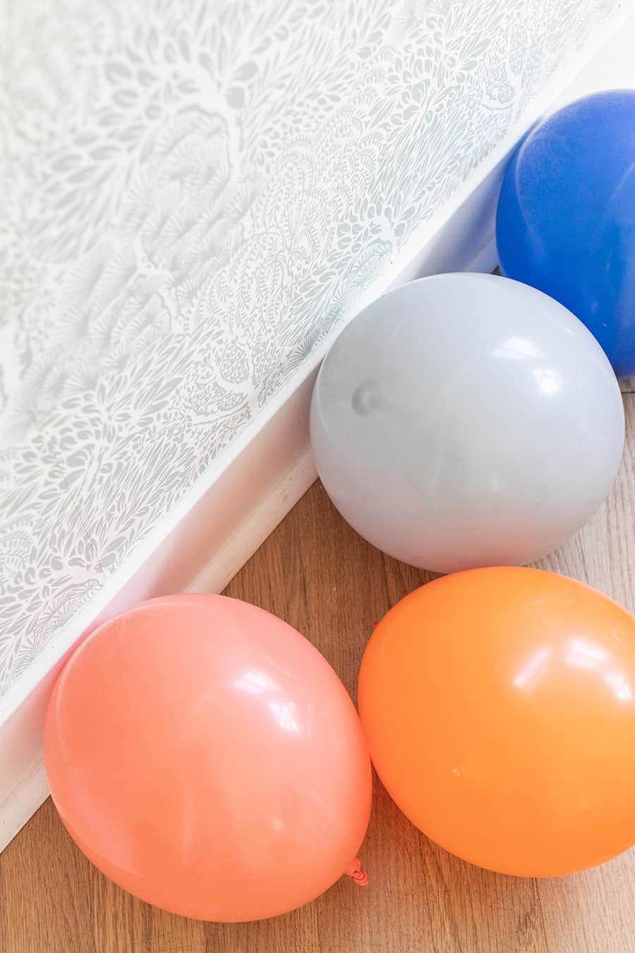 Colorful balloons on a hardwood floor. 