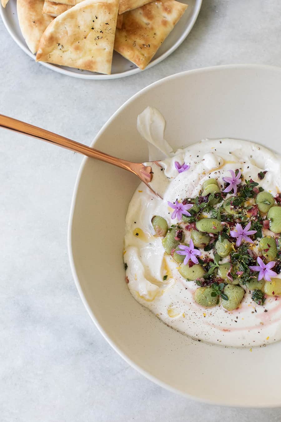 Bowl of yogurt with lima beans, Tahini and thyme perfect for dipping.