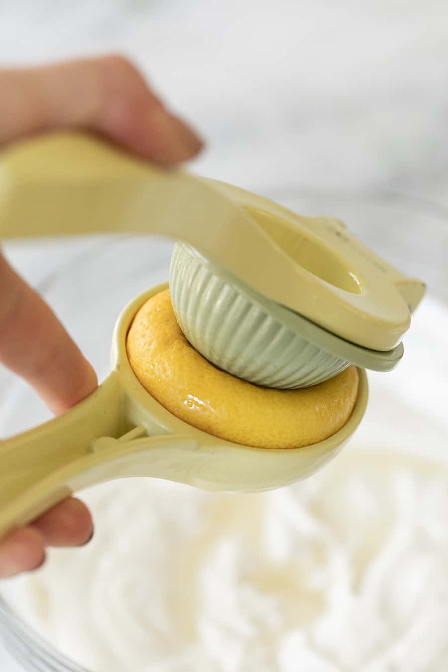 Lemon being juiced in a citrus juicer.