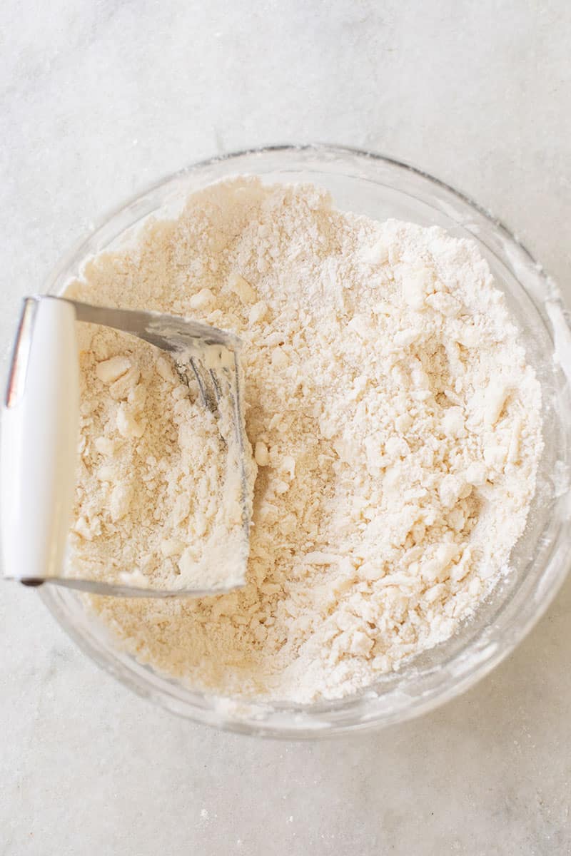 Pastry cutter in a bowl of flour.