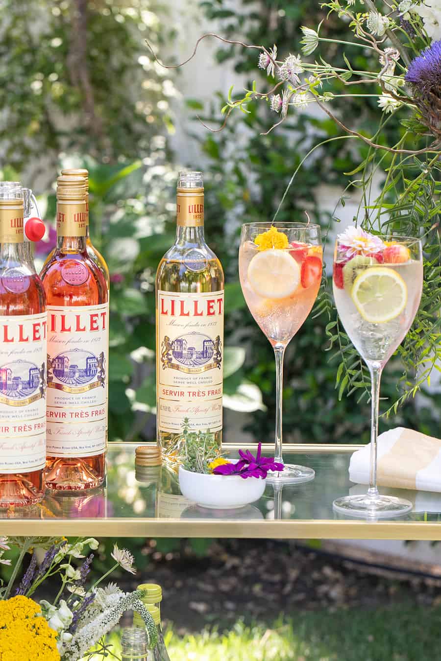 Bottle of Lillet on bar with wine glasses.