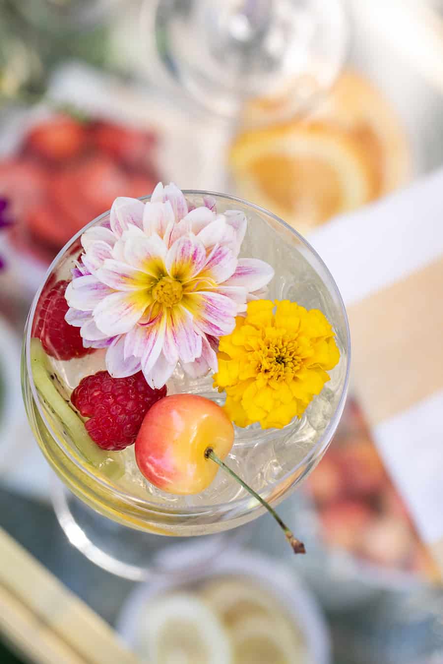 Overhead of cocktails with edible flower and cherries.