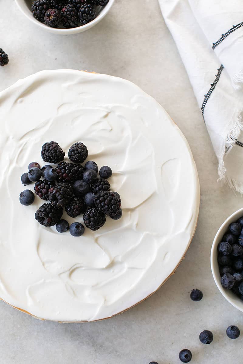 Overhead of ricotta cheesecake with blackberries and blueberries on top. 