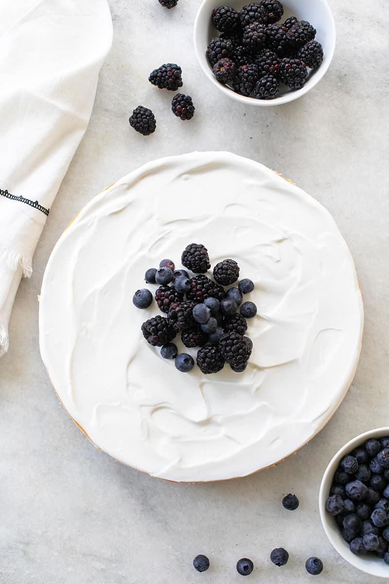 Overhead of a ricotta cheesecake with berries on top. 