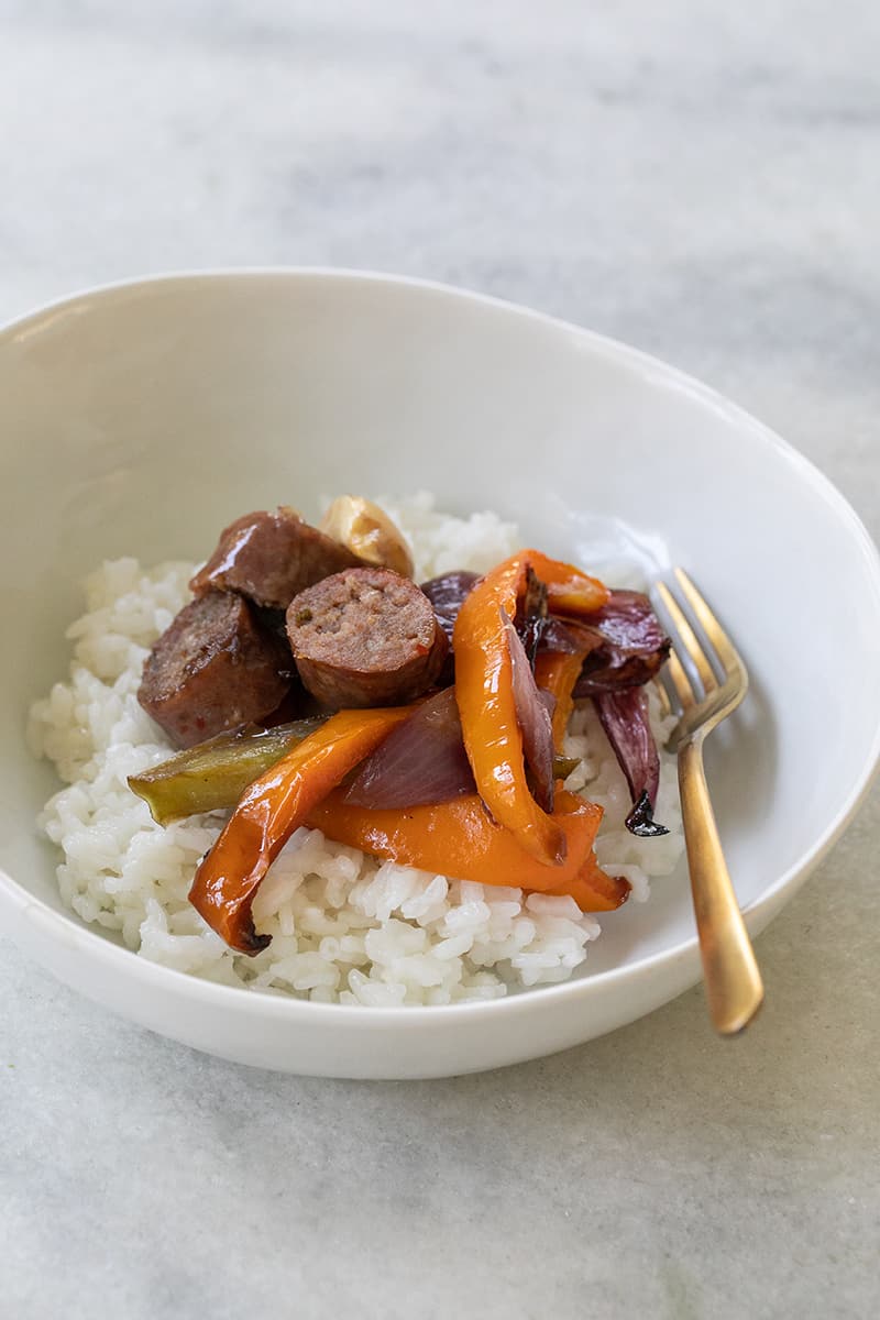 Sausage and Peppers in a bowl with white rice.