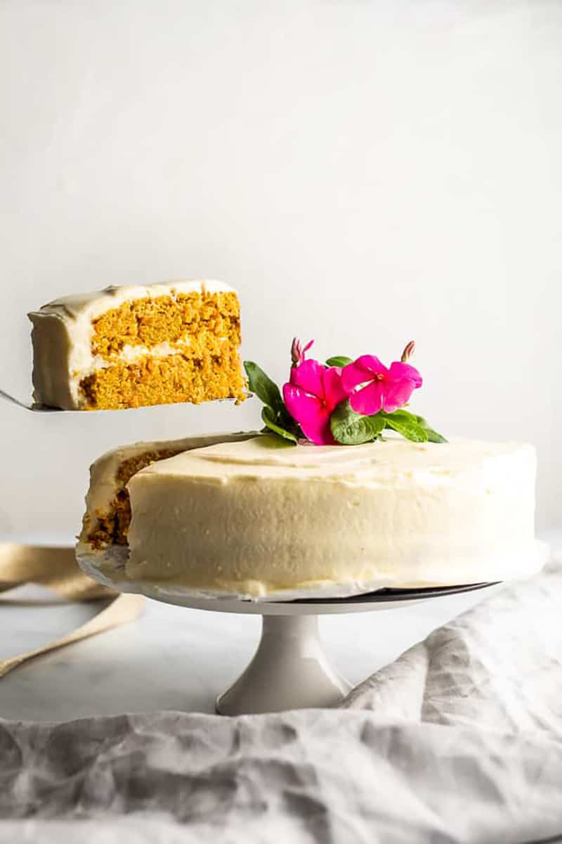 Slice of Keto carrot cake being removed from a cake. 