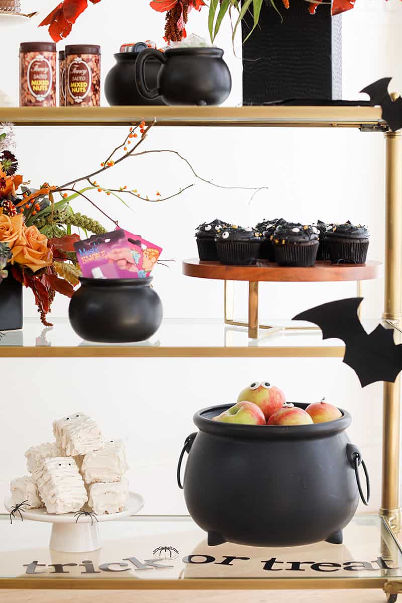 Party decorations, large cauldron with apples, bats, cupcakes and tricks.