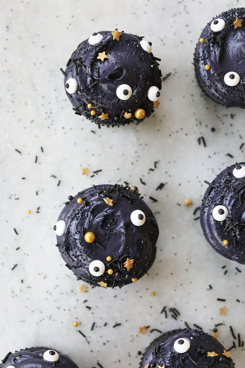 Overhead photo of black velvet cupcakes with sprinkles for Halloween - black gel food coloring, cupcake liners