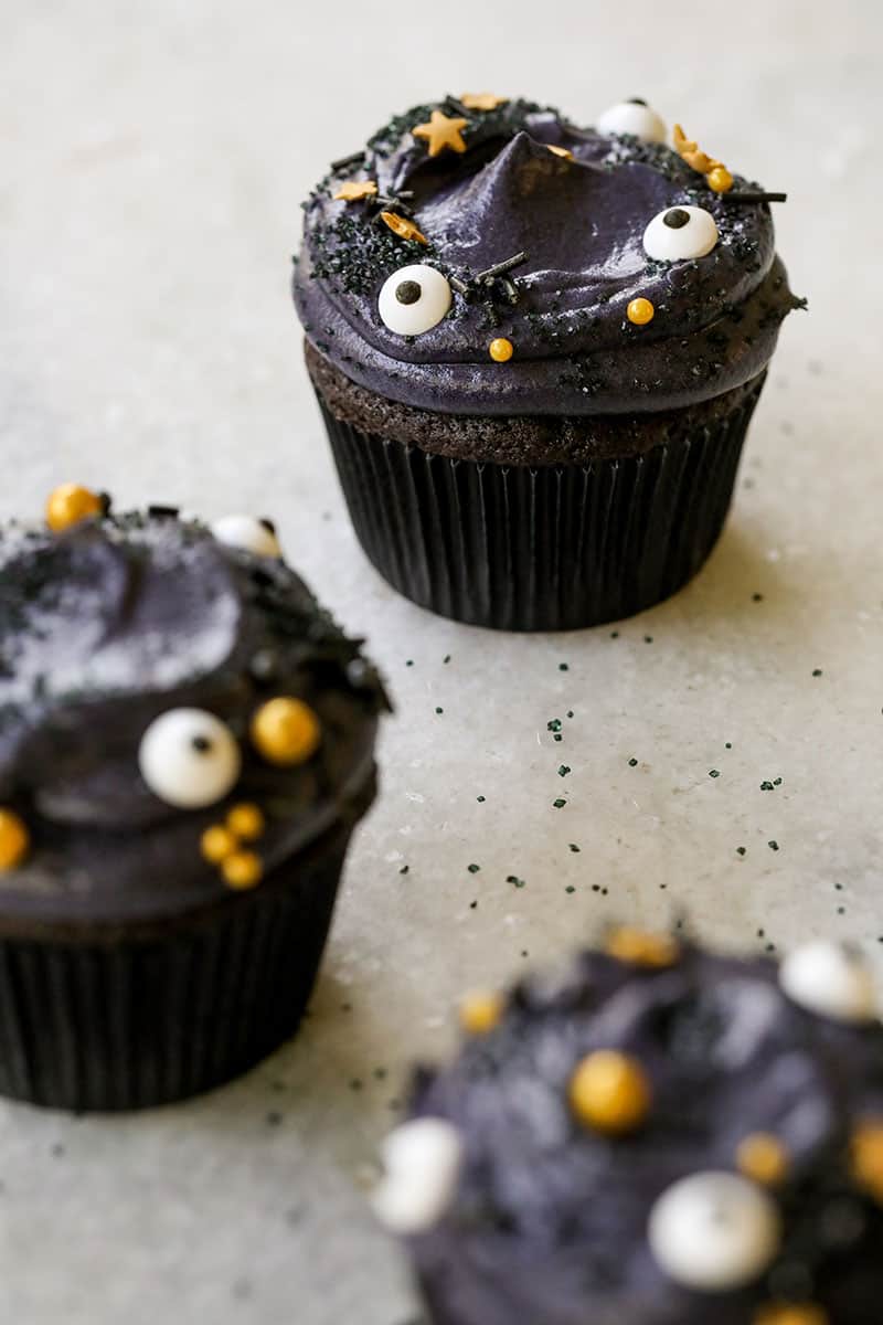 Black velvet cupcakes with whipped cream cheese frosting and sprinkles - cupcake liners